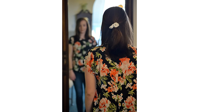 Woman looking at her clothes in the mirror